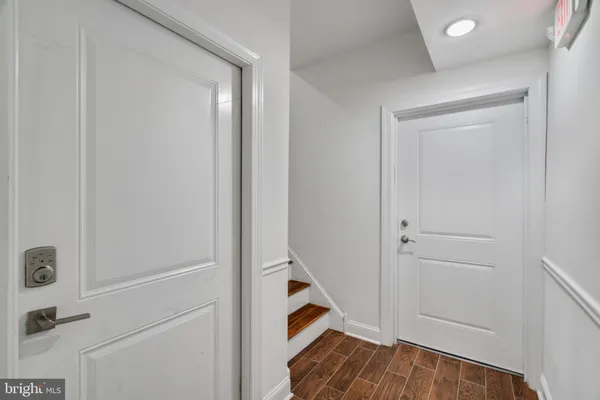 a view of hallway with stairs and wooden floor