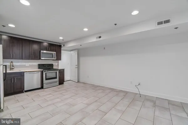 a kitchen with granite countertop a stove top oven and cabinets
