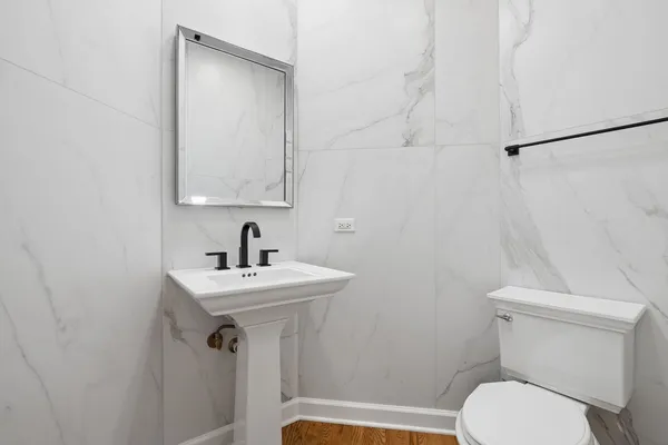 a bathroom with a sink toilet and mirror