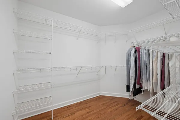 a view of walk in closet with clothes and shoes