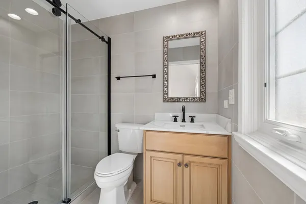 a bedroom with a large bed chandelier and a window