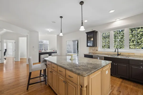 a kitchen with center island wooden floor and a sink