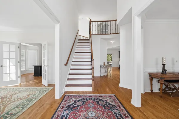 a view of entryway and hall with wooden floor