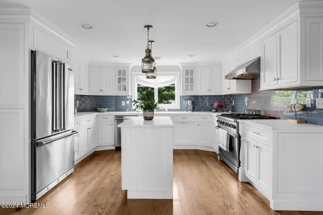 a kitchen with white cabinets and stainless steel appliances