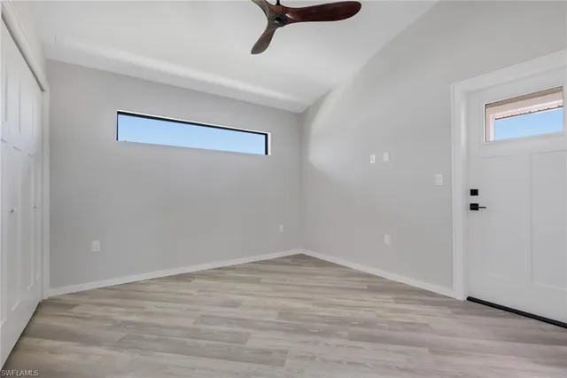 a view of a room with wooden floor and a ceiling fan