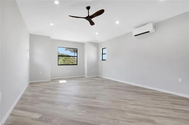 an empty room with windows and fan