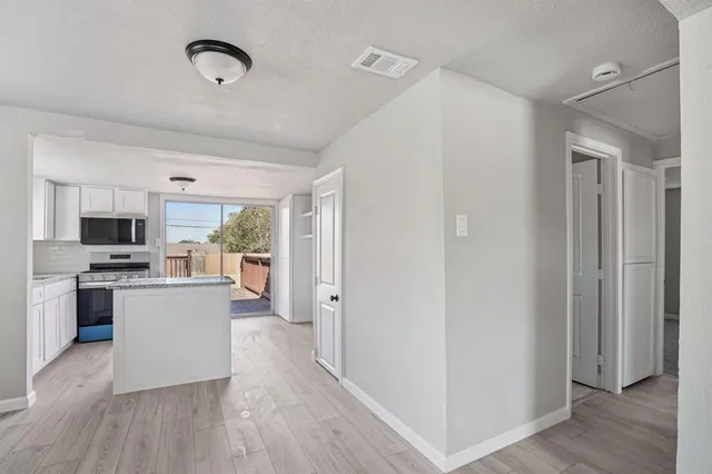 a kitchen with granite countertop a stove a sink and a refrigerator