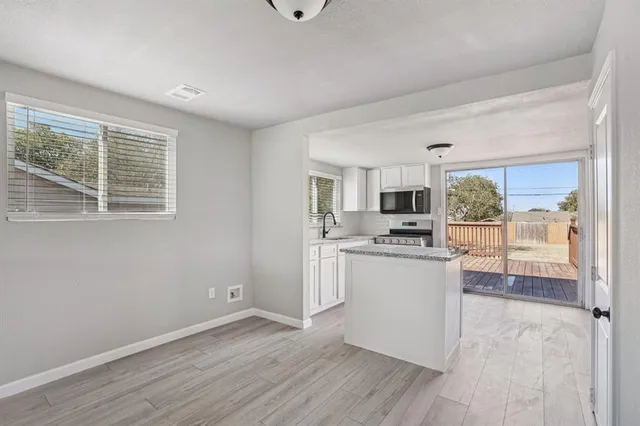 a kitchen with granite countertop a sink stove and microwave