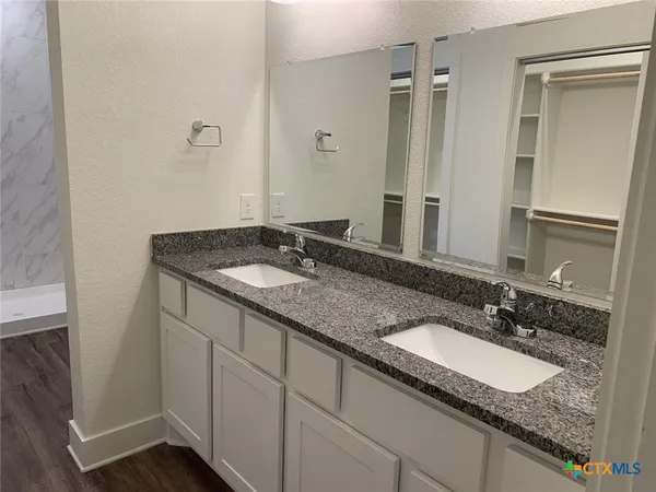 a bathroom with a granite countertop sink and a mirror