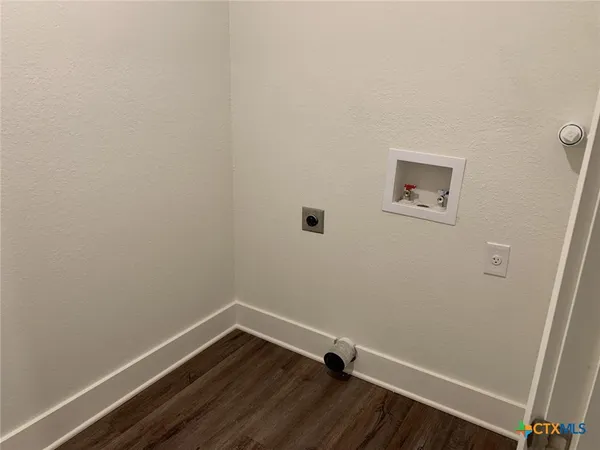 a room with a wooden floor and white walls
