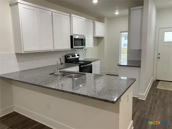 a kitchen with stainless steel appliances granite countertop a sink a microwave counter space and cabinets