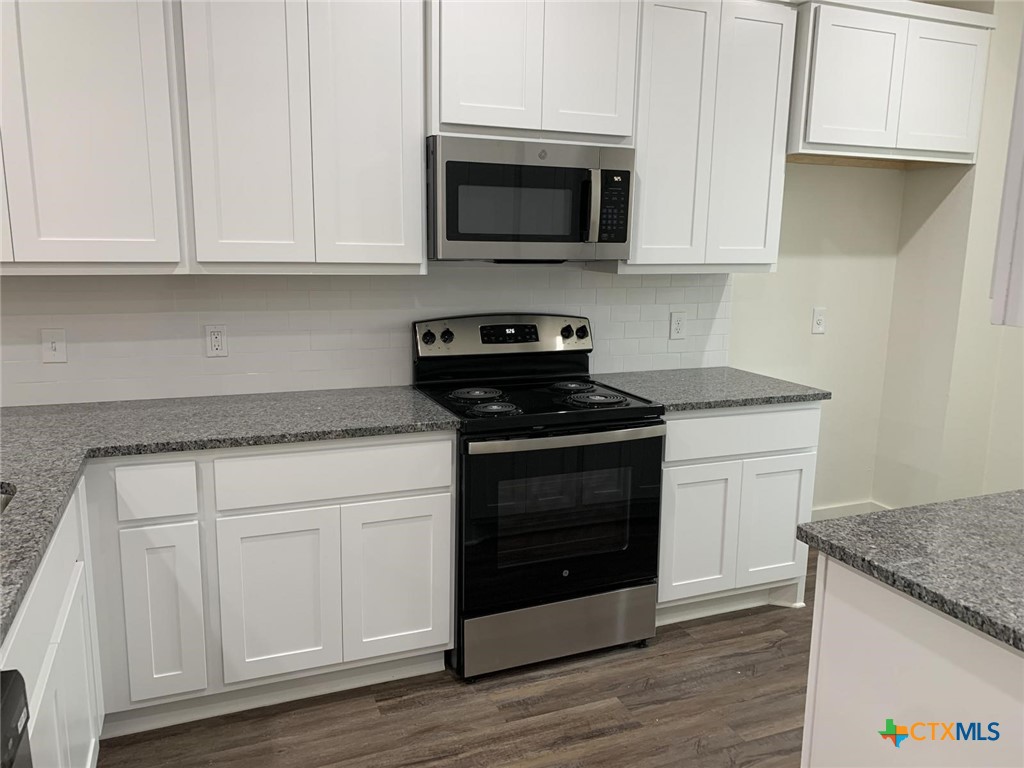 1862 Royal Loop Belton, TX 76513 - Photo 5 of 26 a kitchen with stainless steel appliances granite countertop a stove a microwave and a white cabinets