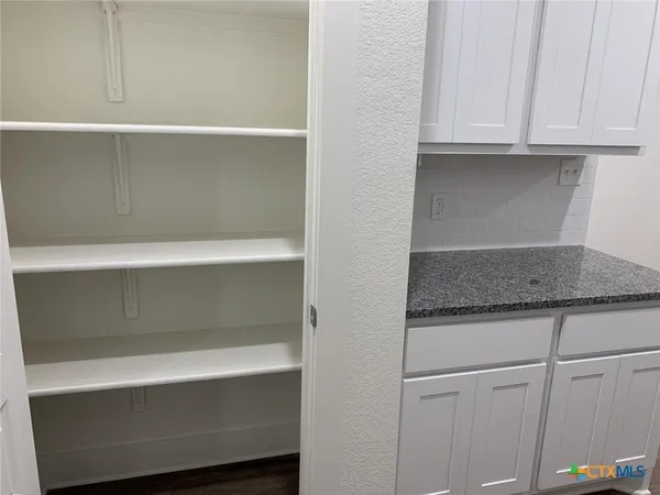 a kitchen with a white cabinets and a refrigerator