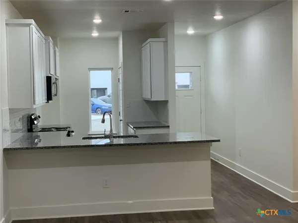 a kitchen with kitchen island a sink and a stove top oven