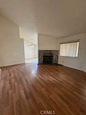 wooden floor fireplace and windows in an empty room