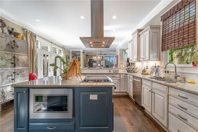 a kitchen with stainless steel appliances kitchen island granite countertop a sink and cabinets