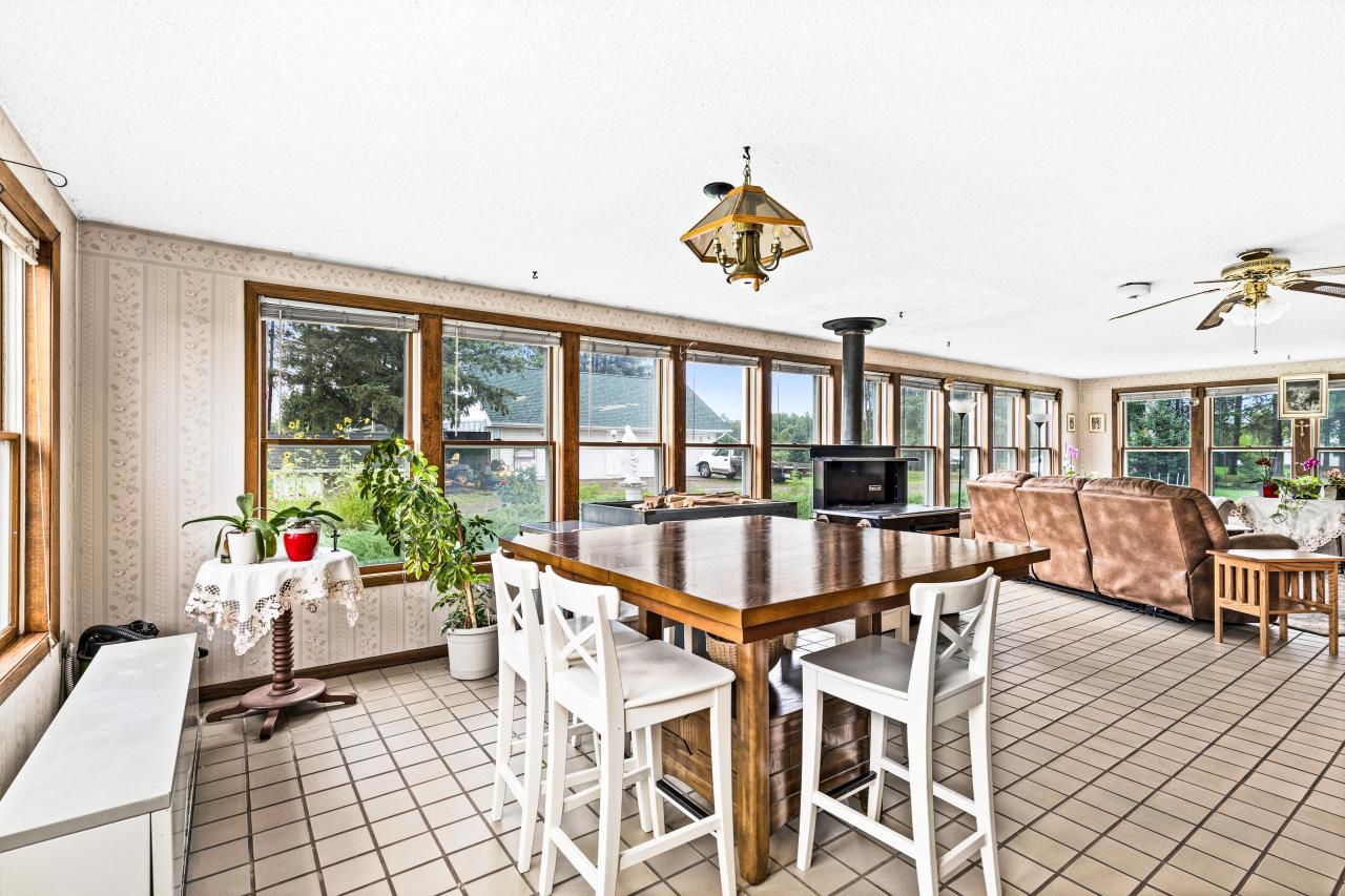 3723 Birchwood Road Kettle River, MN 55757 - Photo 11 of 48 Dining area with a wood stove, healthy amount of natural light, light tile patterned floors, and ceiling fan