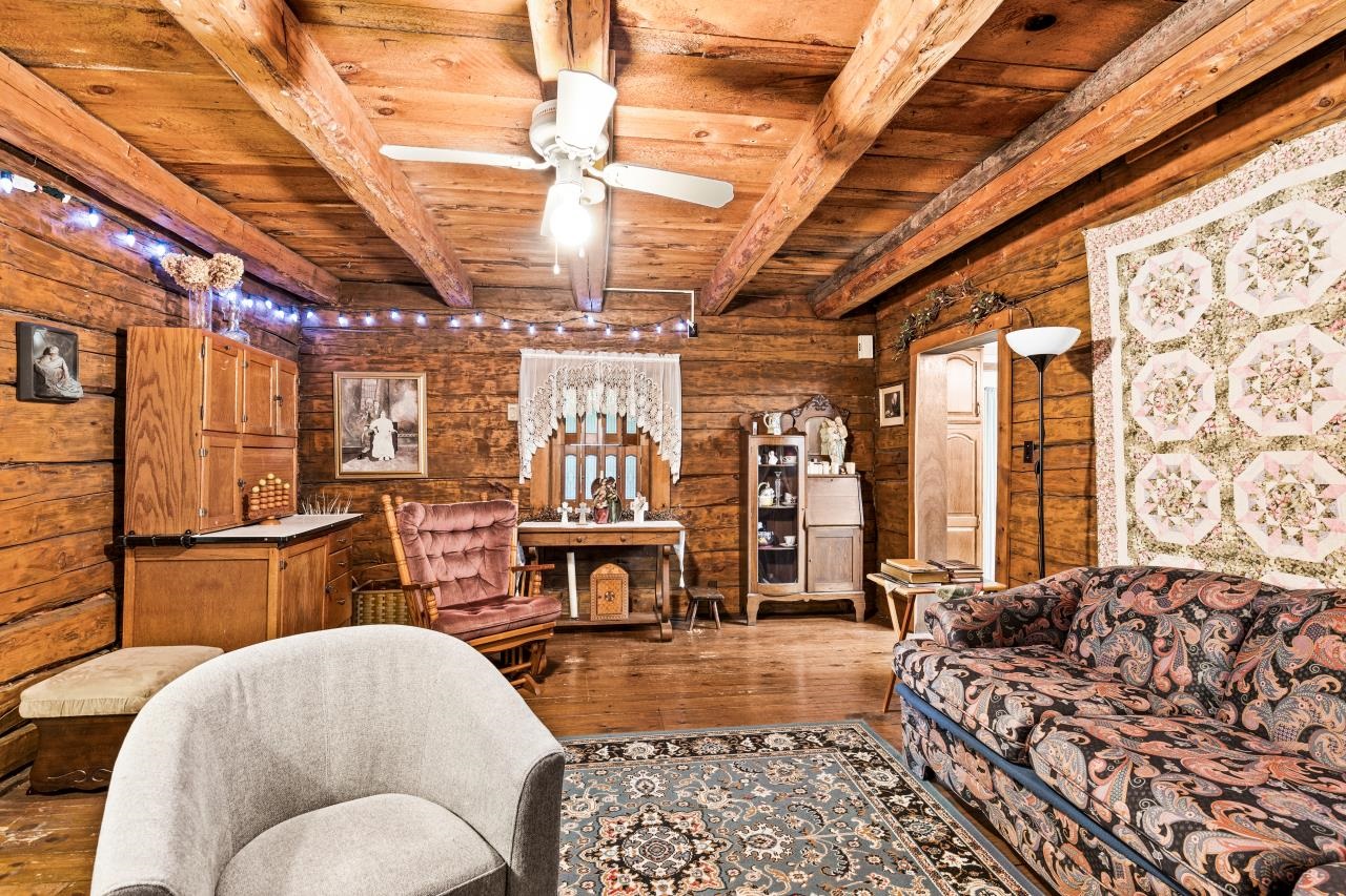 3723 Birchwood Road Kettle River, MN 55757 - Photo 26 of 48 Living area featuring a wooden ceiling with exposed beams, hardwood / wood-style floors, wooden walls, and a ceiling fan