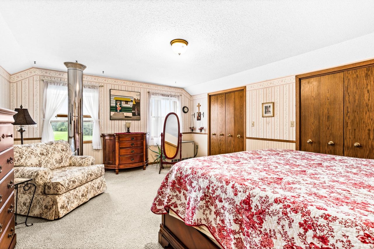 3723 Birchwood Road Kettle River, MN 55757 - Photo 28 of 48 Bedroom with wallpapered walls, multiple closets, light carpet, lofted ceiling, and a textured ceiling