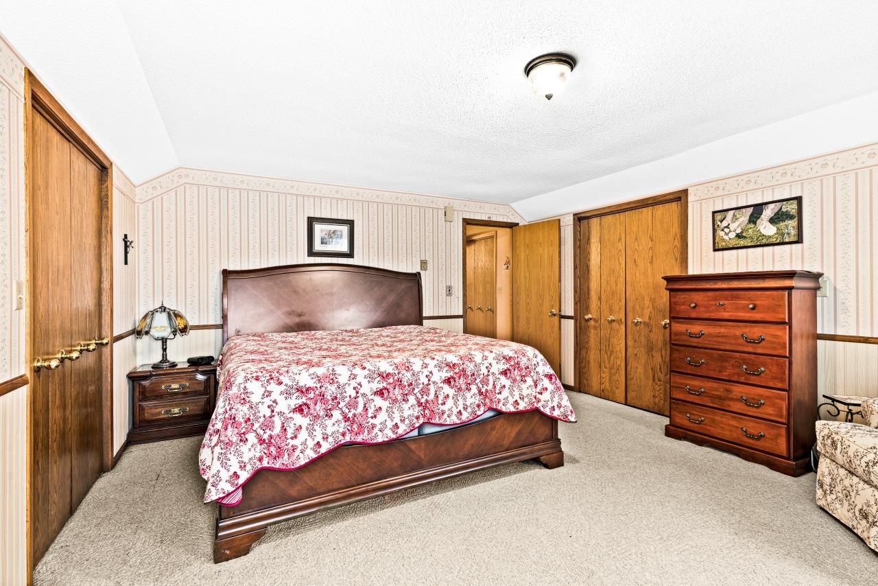 3723 Birchwood Road Kettle River, MN 55757 - Photo 29 of 48 Carpeted bedroom featuring lofted ceiling, wallpapered walls, multiple closets, and a textured ceiling
