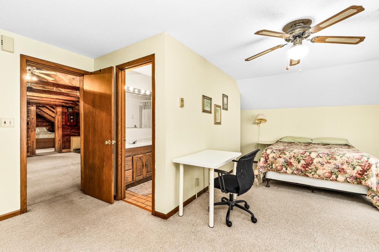 3723 Birchwood Road Kettle River, MN 55757 - Photo 42 of 48 Bedroom with light colored carpet, lofted ceiling, ensuite bath, a ceiling fan, and an office area