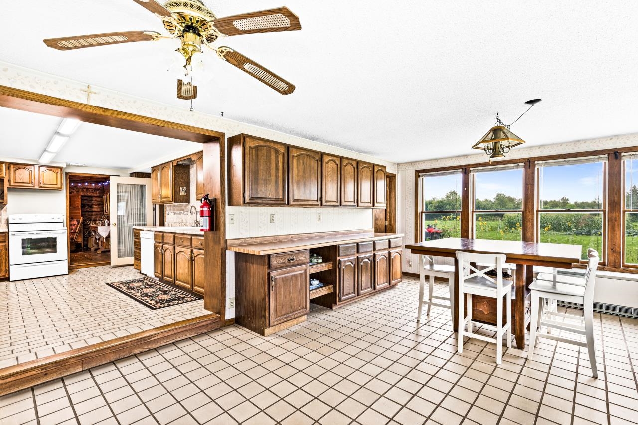 3723 Birchwood Road Kettle River, MN 55757 - Photo 7 of 48 Kitchen with light countertops, light tile patterned floors, white appliances, ceiling fan, and brown cabinets