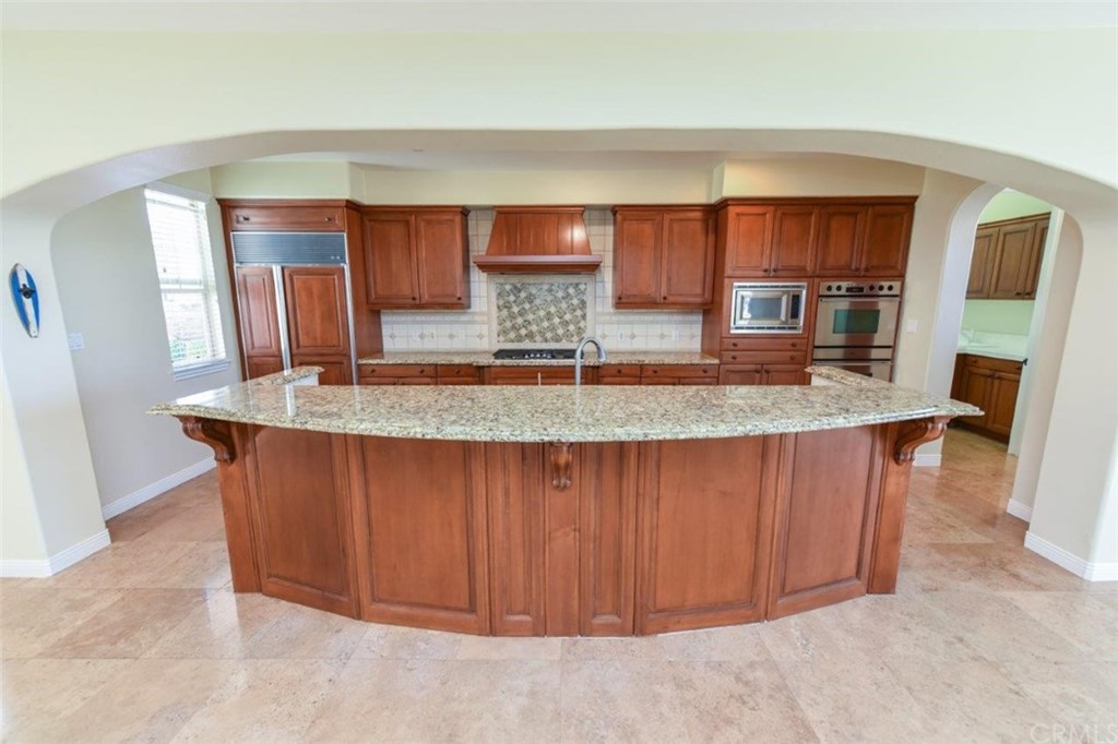 19 Ferrand Newport Coast, CA 92657 - Photo 30 of 74 a kitchen with kitchen island granite countertop wooden cabinets a sink and dishwasher