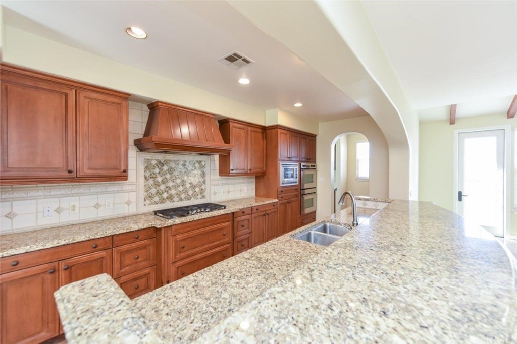 19 Ferrand Newport Coast, CA 92657 - Photo 33 of 74 a large kitchen with stainless steel appliances kitchen island granite countertop a sink and cabinets