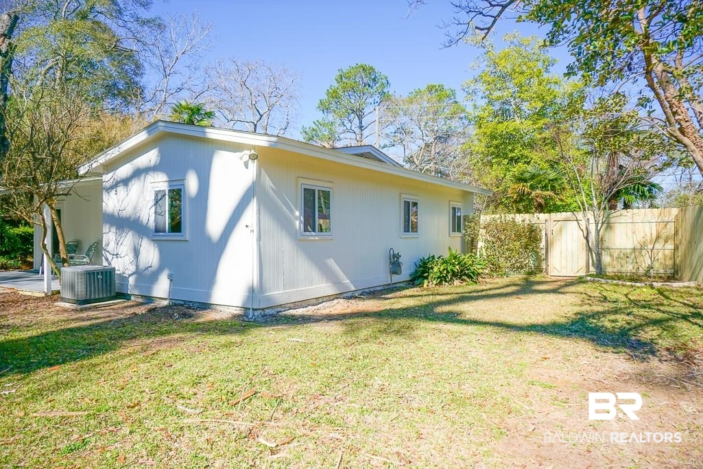 4159 Rebecca Road Mobile, AL 36609 - Photo 13 of 19 Back of house with central AC, fence, and a lawn