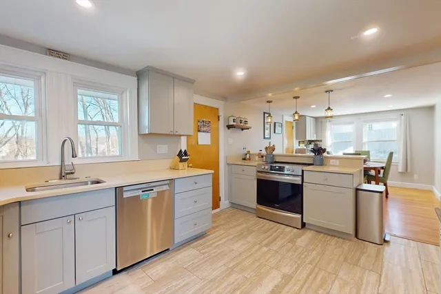 a large kitchen with a lot of counter space and wooden floor