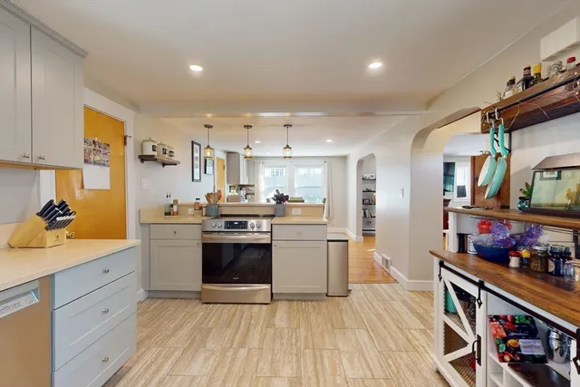 a kitchen with stainless steel appliances kitchen island granite countertop a sink cabinets and wooden floor