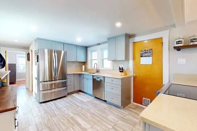 a kitchen with stainless steel appliances a refrigerator and wooden floor