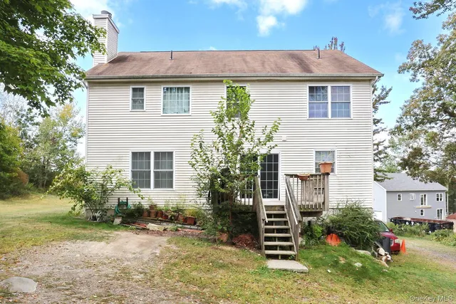 a view of a house with a yard and sitting area