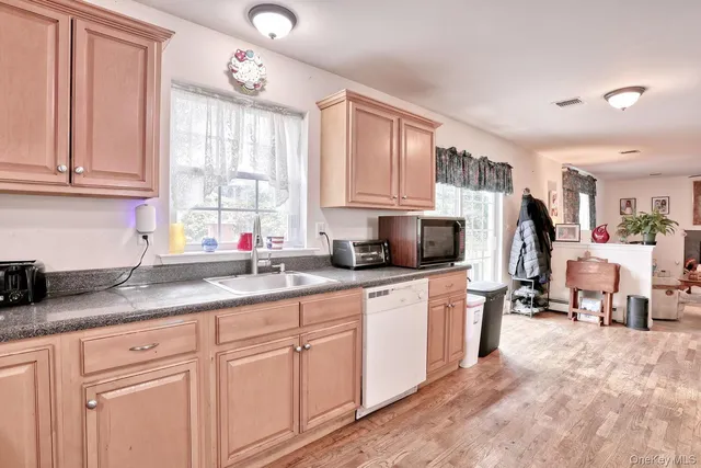 a kitchen with granite countertop a sink stainless steel appliances and cabinets