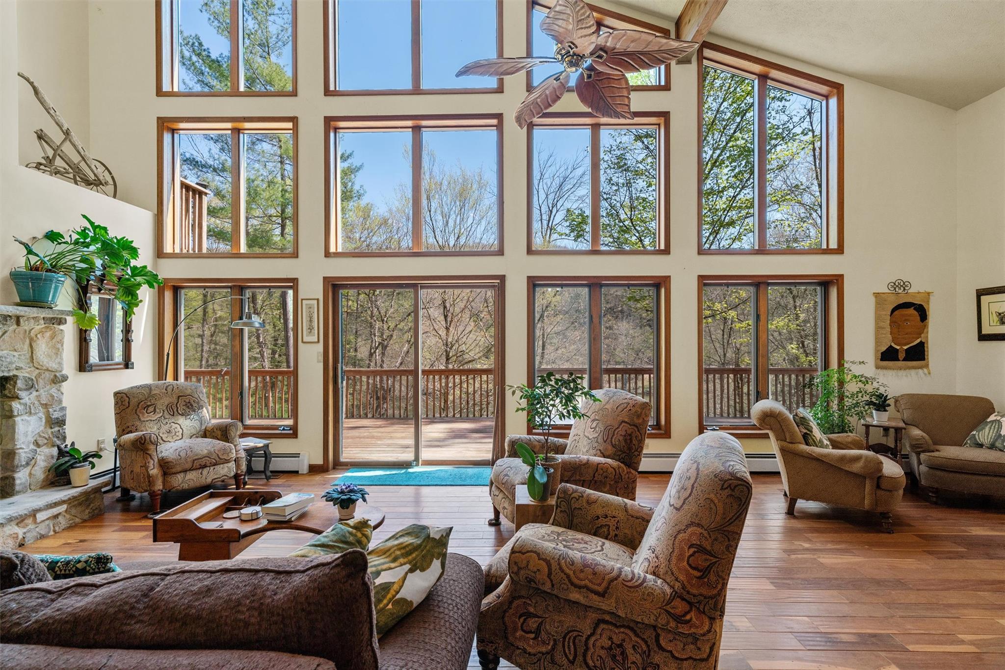 216 Cortese Road Beach Lake, PA 18405 - Photo 1 of 1 Living area featuring a towering ceiling, a baseboard radiator, a ceiling fan, and hardwood / wood-style flooring