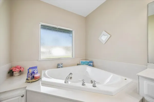a spacious bathroom with a double vanity sink mirror and bathtub