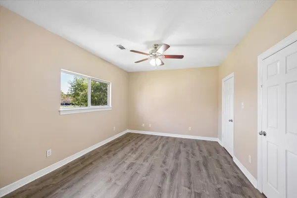an empty room with a window and a ceiling fan