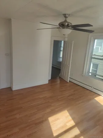 a view of a big room with wooden floor and windows