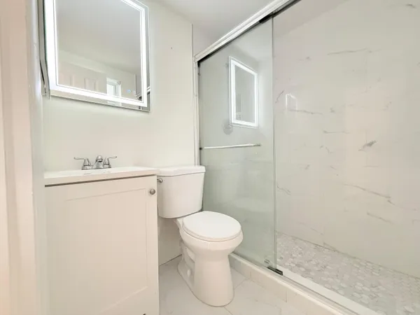 a white toilet sitting next to a bathroom sink