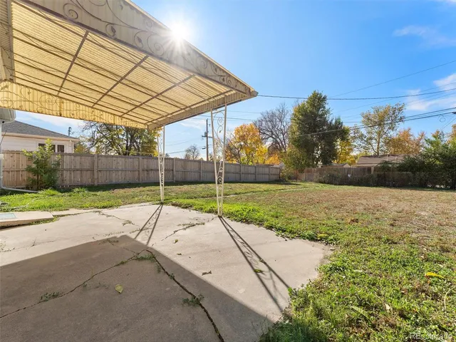 a view of a backyard with wooden fence