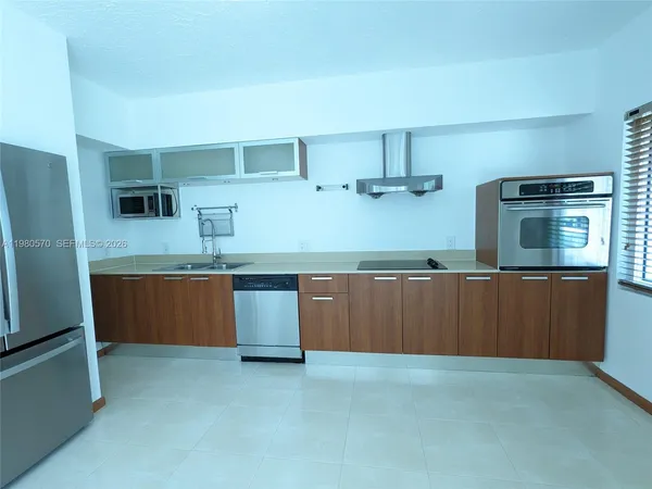 a kitchen with stainless steel appliances granite countertop a sink a stove and refrigerator