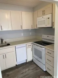 a kitchen with white cabinets and white appliances