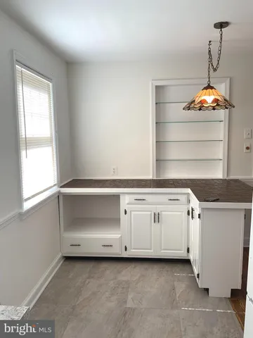 a kitchen with granite countertop white cabinets and white appliances