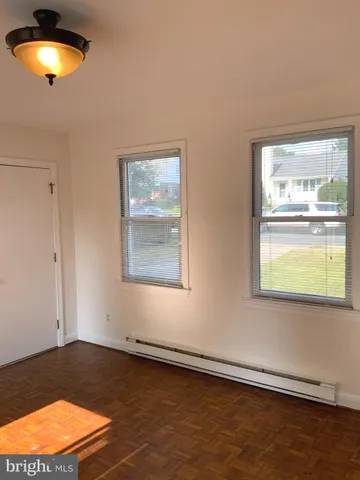 an empty room with a window and wooden floor
