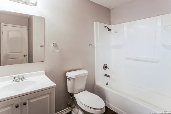 a white toilet sitting next to a bath tub
