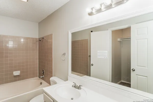 a bathroom with a bathtub shower sink and a toilet