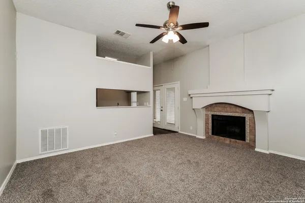 a view of empty room with fireplace and fan