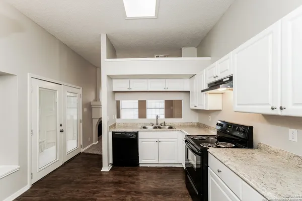 a kitchen with a stove sink and cabinets