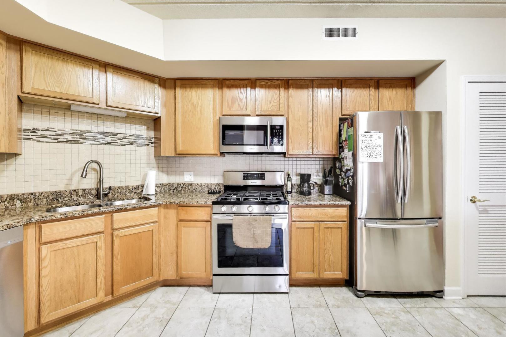 77 North Wolf Road, Unit 312 Northlake, IL 60164 - Photo 2 of 19 a kitchen with stainless steel appliances granite countertop a stove a sink and a refrigerator