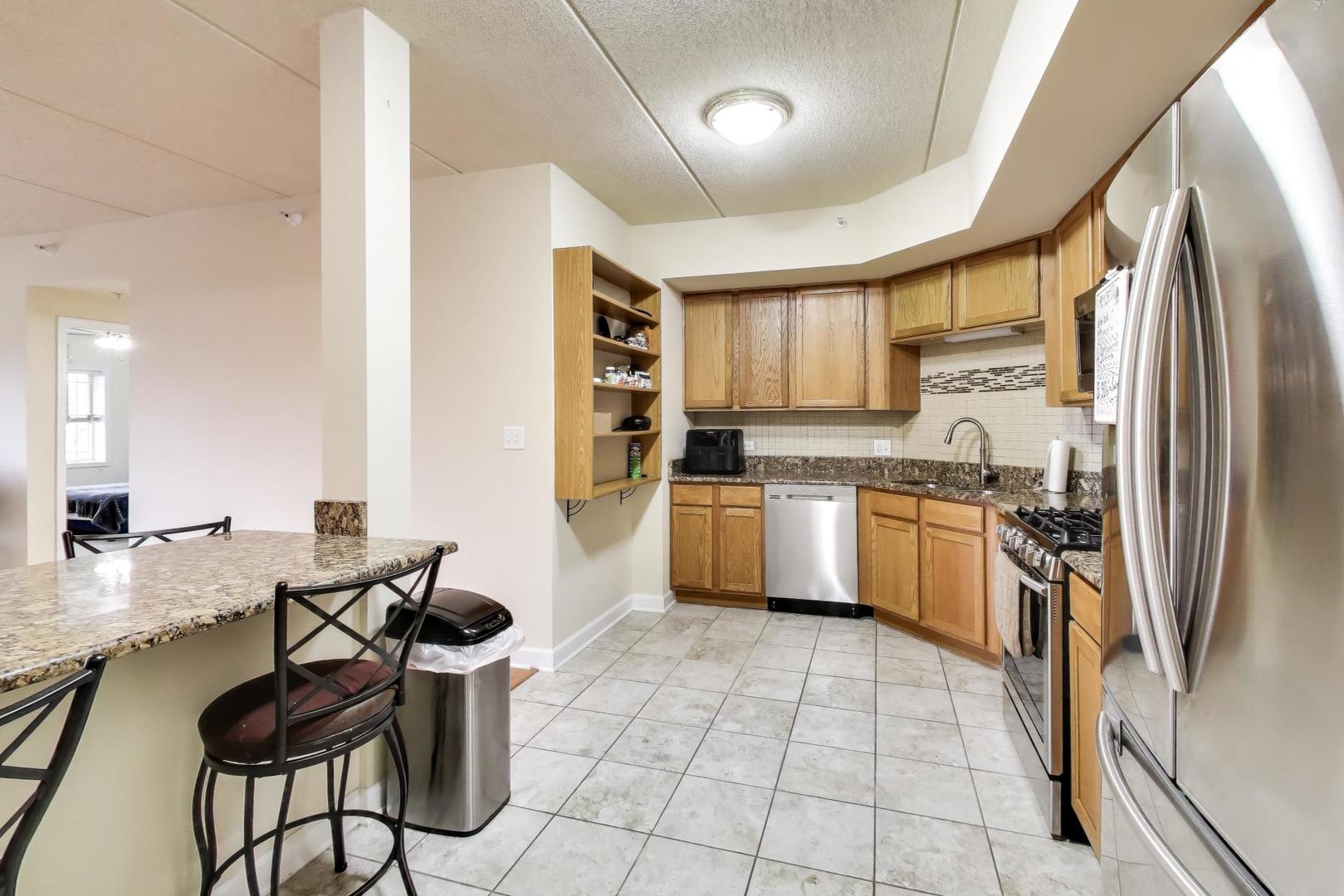 77 North Wolf Road, Unit 312 Northlake, IL 60164 - Photo 3 of 19 a kitchen with stainless steel appliances granite countertop a stove a sink dishwasher a refrigerator and cabinets with wooden floor